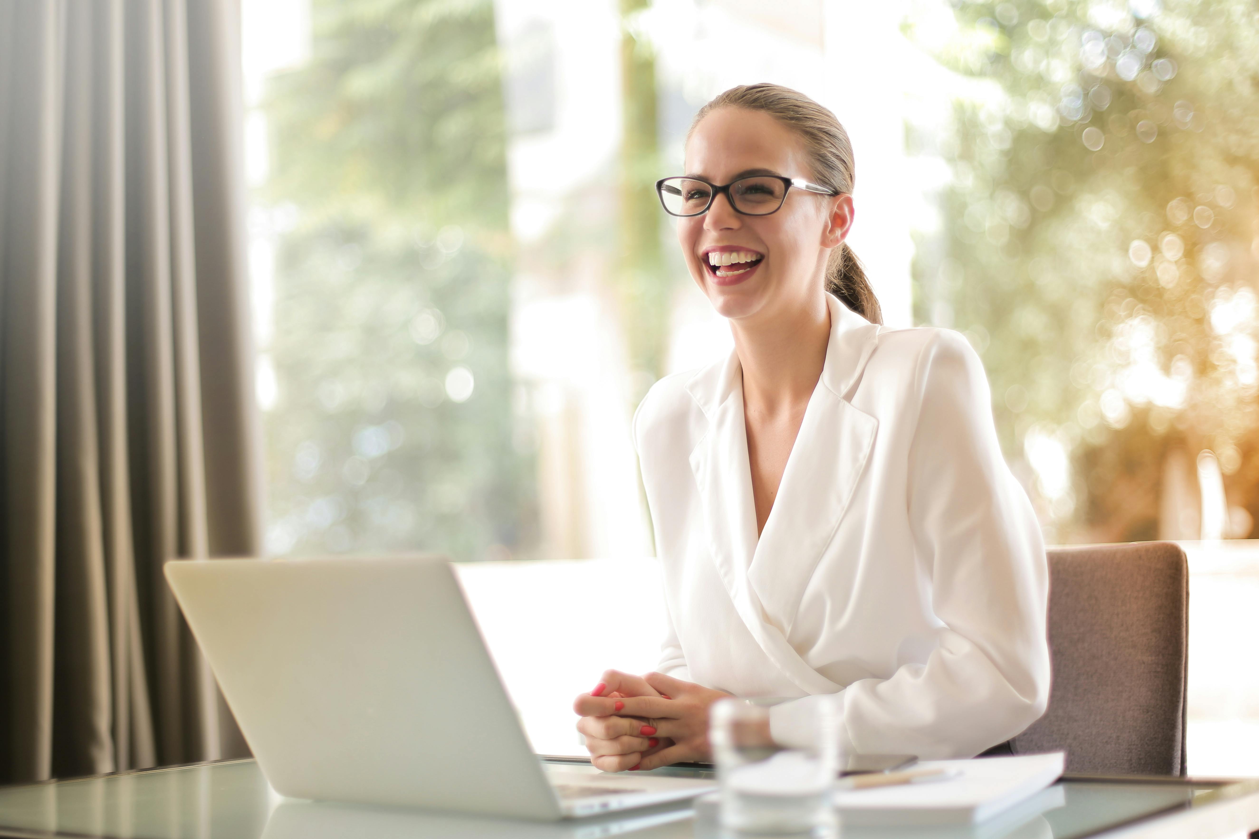 Woman laughing behind computer